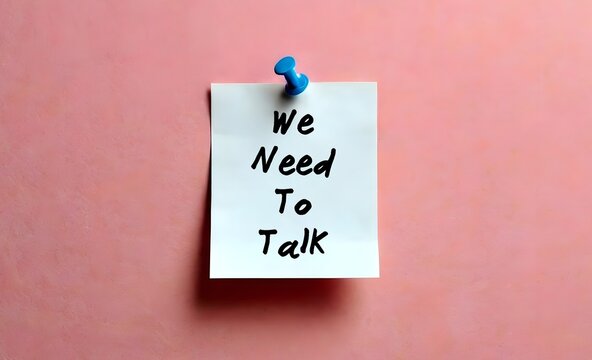 Paper note on pink wall written WE NEED TO TALK, means there is serious problem that needs to be discussed, partners serious conversation generally followed by relationship ending