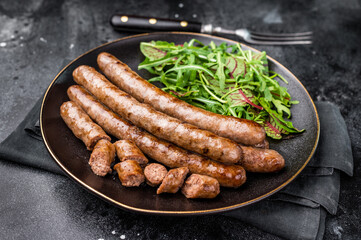 Smoky grilled sausage with grill marks, perfect for satisfying cravings at barbecues and casual dining events. black background. top view