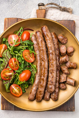 Close up of perfectly charred grilled sausage with salad, ideal for adding flavor to your favorite dishes or sandwiches. white background. top view
