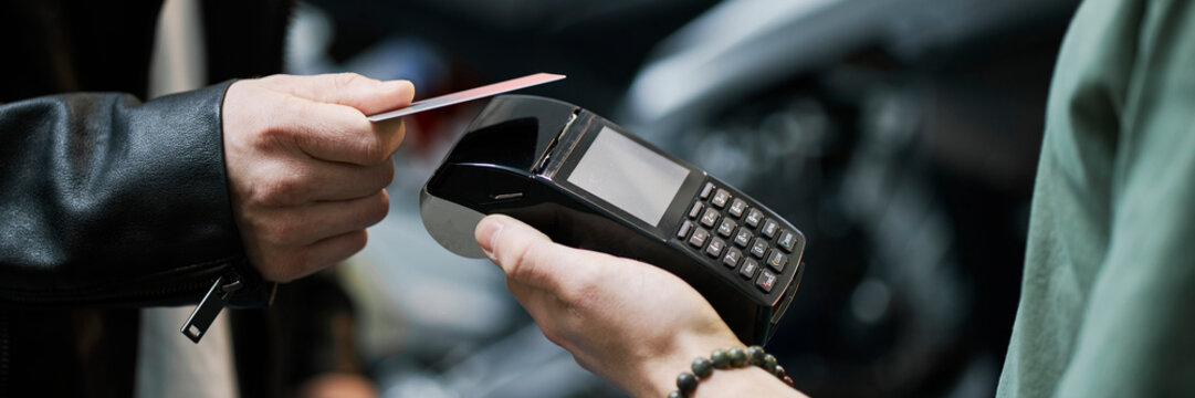 Client paying with credit card at garage using payment terminal