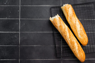 French bread baguette on a steel rack. black background. top view