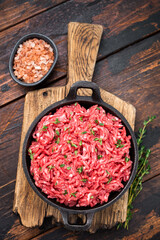 Veal beef raw mince meat, forcemeat in a skillet, on wooden background.