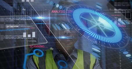 Monitoring engineer viewing holographic interface at industrial site, wearing helmet, safety vest