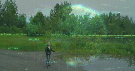 Standing woman surveying gravel clearing at water edge, with puddles, data grid overlay, copy space