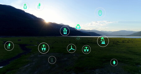 Displaying mountain ridge overlaying sustainability and energy icons over plain and lake at sunrise
