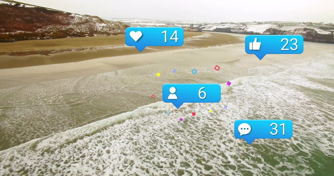 Floating blue social media icons hovering over coastal bay aerial view, with snowy hills behind - Powered by Adobe