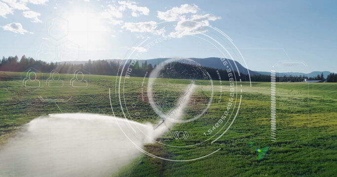 Fototapeta Spraying irrigation sprinkler head misting rural meadow with overlaid HUD graphics, copy space
