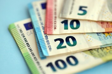 Big amount of european euro currency money notes on blue color table close up