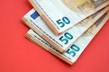 Big amount of european euro currency money notes on red color table close up