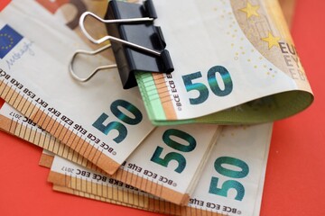 Big amount of european euro currency money notes on red color table close up