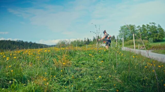 A Man Trims Overgrown Grass Along a Countryside Path on a Sunny Day - Timelapse
