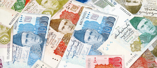 Pakistan rupees banknotes. The current Pakistan money bills lies on table in big amount