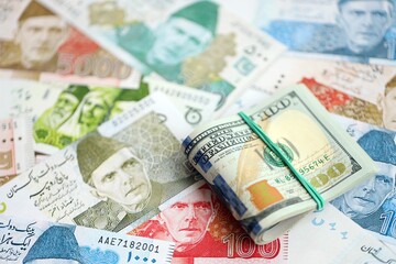 Bunch of US dollar bills lies on big amount of Pakistan rupees banknotes close up