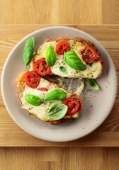 Hot open sandwiches with mozzarella, tomatoes and basil.