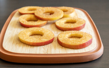 fresh apple slices coated with brown sugar and cinnamon, arranged on a rustic wooden board. Perfect for fall baking, cozy recipes