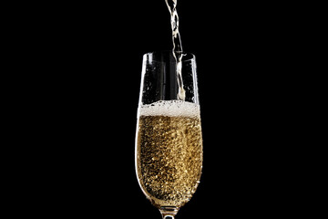 Golden Champagne Pouring into a Flute Glass Against a Dark Background, Showcasing Effervescence and Celebratory Bubbles