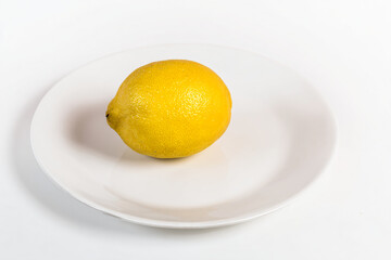 a lemon on a white plate on a white surface