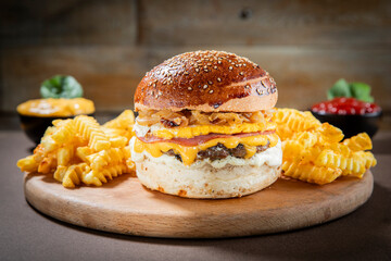 Breakfast Cheeseburger with Egg, Caramelized Onions, and Crinkle-Cut Fries on Wooden Plate