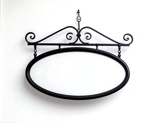 Ornate black metal oval sign hangs against a white wall