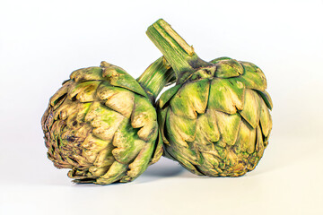 Fototapeta premium two artichokes are sitting on a white surface