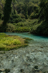 Fototapeta premium Vertical photo of Blue Eye spring (Syri i Kalter) in southern Albania, featuring turquoise water, forest surroundings, and vibrant nature.