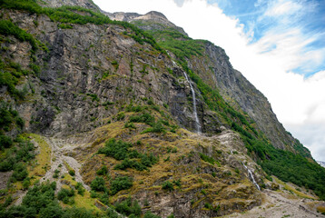 Majestic mountain landscape with cascading waterfall and lush greenery