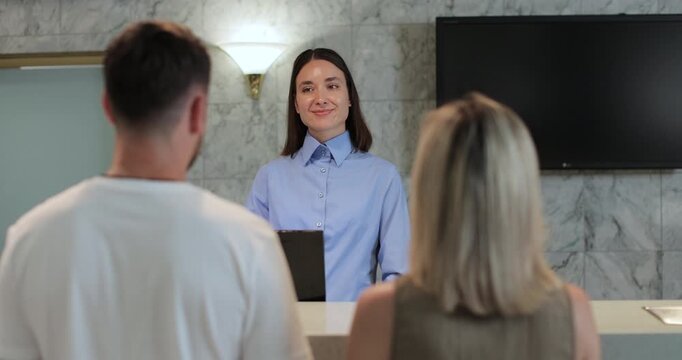 Administrator giving tourist man key card at hotel desk. Concierge service, woman smile in lobby for check in assistance, reservation and help.