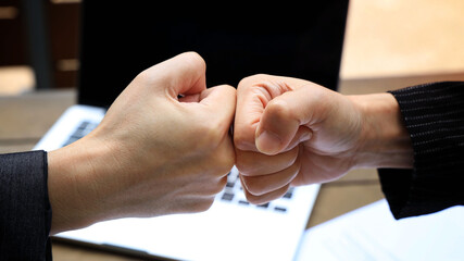 Fototapeta premium Deal of teamwork with the Man hand a fist bump commit as get together in the office
