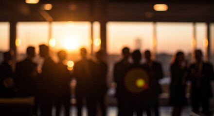 Silhouettes of a corporate group in a modern office with a blurred background of a city sunset and bokeh lights, representing success.