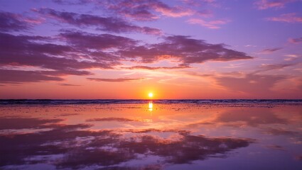 Fototapeta premium Beautiful, dramatic orange and red sunset over the tranquil sea with clouds and sunlight on the horizon