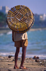indian porter walking on the beach india 