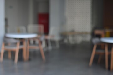 Abstract Interior Blurred Tables and Chairs in a Modern Cafe Setting.
