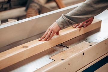 Carpenter Cutting Wooden Beam Using Table Saw in Workshop