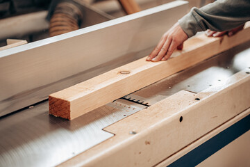 Carpenter Cutting Wooden Beam Using Table Saw in Workshop