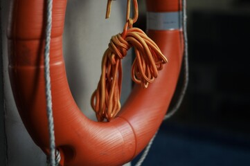 Orange Lifebuoy with Knotted Rope Safety Equipment CloseUp Maritime Rescue Aid.