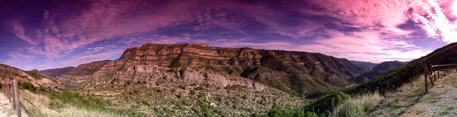 foto panorámica de montañas con un cielo de nubes rojas en el cañón del rio Júcar 