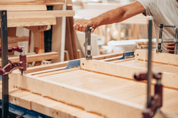 Woodworker Clamping Wooden Panel for Gluing and Assembly
