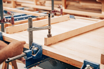 Woodworker Clamping Wooden Panel for Gluing and Assembly
