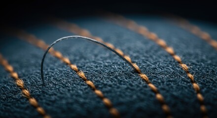 Macro Photography of a Single Silver Thread Arcing Over Teal Fabric with Orange Stitching