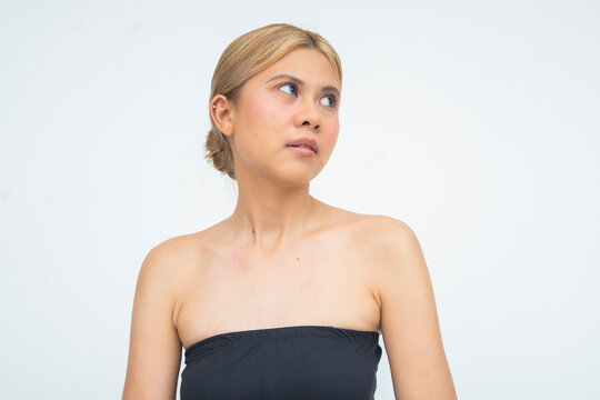 A sassy young Asian woman giving a rude eye roll, her face showing clear snobbery. Isolated on a white background.