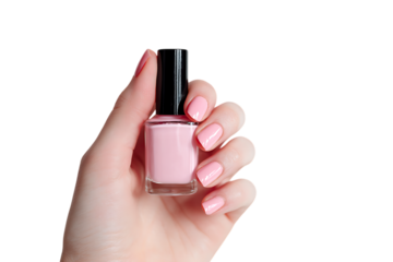 Woman's hand holding a bottle of pale pink nail polish.