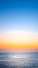 Obraz premium A breathtaking coastal landscape at sunrise, with a vibrant sky, calm water, and a tranquil horizon
