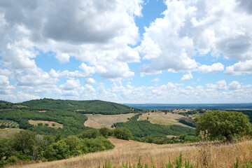 landscape of tuscany with blue sky with clouds and hills and trees