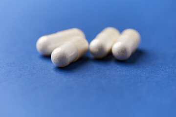 Creatine capsules on paper background. Soft focus. Close up. Copy space.