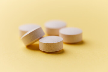 Creatine tablets on paper background. Soft focus. Close up. Copy space.
