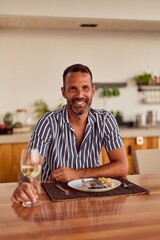 Man Enjoying Dinner With Wine in Modern Indoor Dining Space
