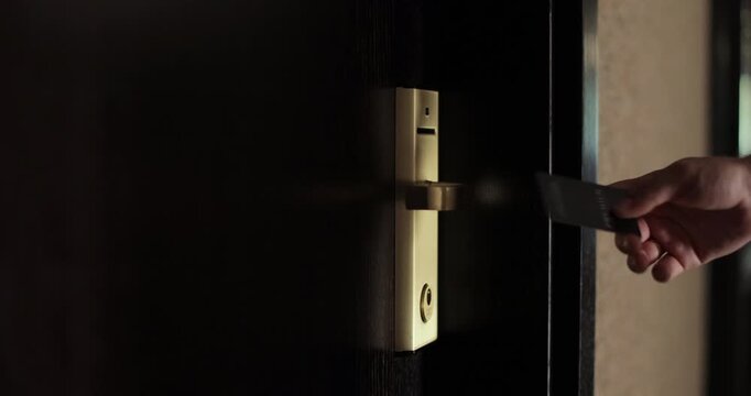 Close up of female hand open hotel room door with electronic card key. Protection and security system concept.