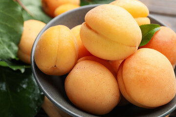 Fresh apricots in bowl on table, closeup