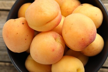 Fresh apricots in bowl on table, top view
