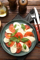 Tasty salad Caprese served on wooden table, flat lay